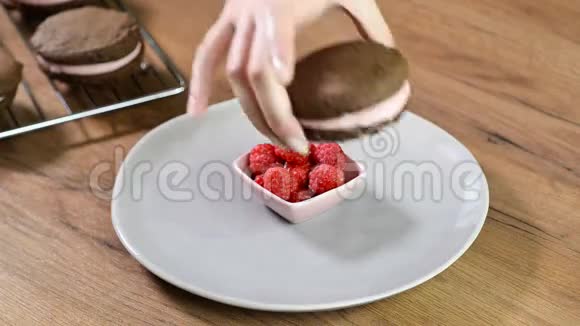 女人手把一块巧克力饼干放进碗里视频的预览图
