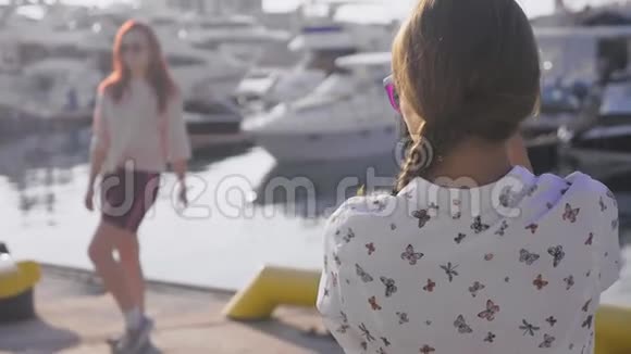 专业摄影师在海港的游艇背景下拍摄的照片一位女士按下按钮与她交谈视频的预览图