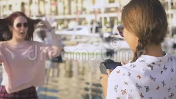 专业摄影师在海港的游艇背景下拍摄的照片一位女士按下按钮与她交谈视频的预览图