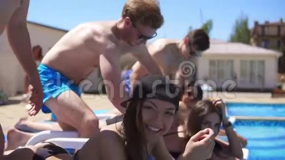女人在泳池边的一个漂亮别墅接受男友的按摩慢镜头视频的预览图