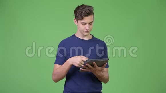 年轻英俊的少年使用数码平板电脑视频的预览图