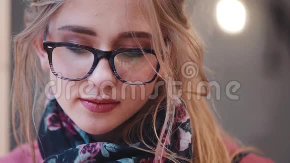 一位戴着时尚眼镜的年轻可爱女子的近景自然的妆容正朝镜头明亮的方向看视频的预览图