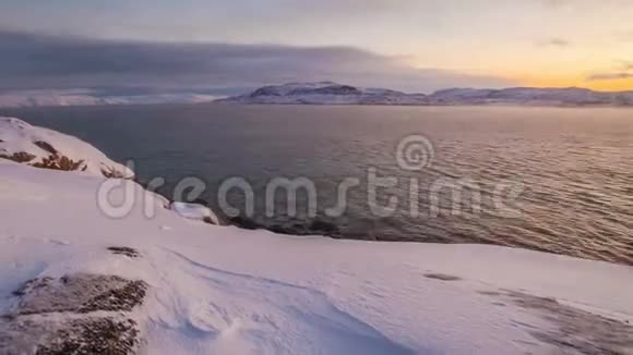 巴伦支海冰雪覆盖的海岸日落视频的预览图