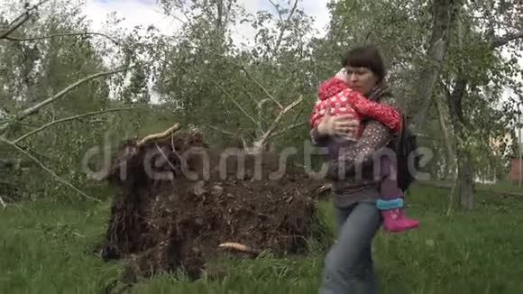 一位母亲带着一个孩子靠近风倒树视频的预览图