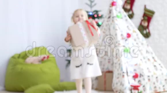 这孩子正拿着一件礼物给照相机圣诞节的心情奇迹和礼物的时间视频的预览图