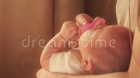 妈妈用粉红色的奶嘴安抚她挑剔的新生儿视频的预览图