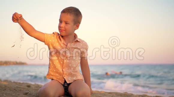日落时在海边玩沙子的小孩视频的预览图