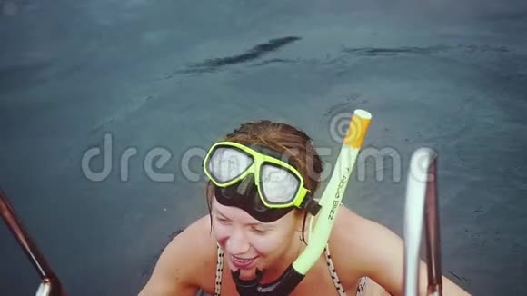 穿比基尼的年轻快乐女子戴着面具从游艇上潜入水中浮潜看鱼视频的预览图