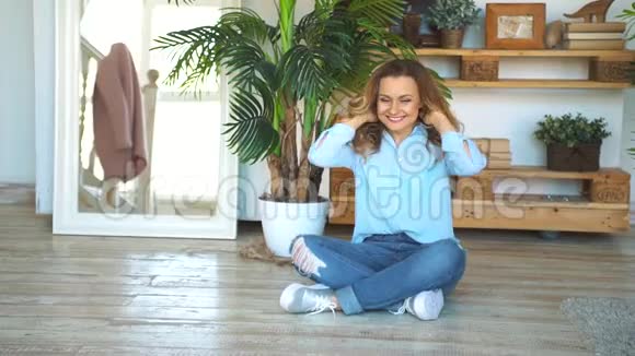 幸福的成年女人双手抱着膝盖坐在自家地板上视频的预览图