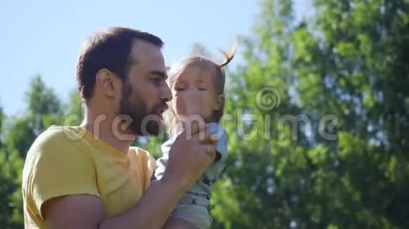 年轻的父亲在户外玩耍和呕吐他的小女儿视频的预览图