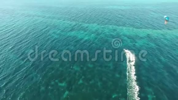 人们在风和日丽的夏日在清澈的蓝色绿松石海水中风筝在华丽的4k空中无人机海景全景中飞翔视频的预览图