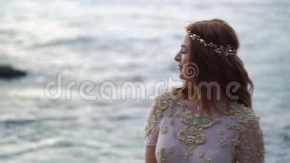 傍晚或日落时在海边的年轻新娘在海洋附近浪漫视频的预览图