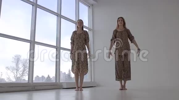 两位欧洲女性一起做瑜伽练习鹰姿视频的预览图