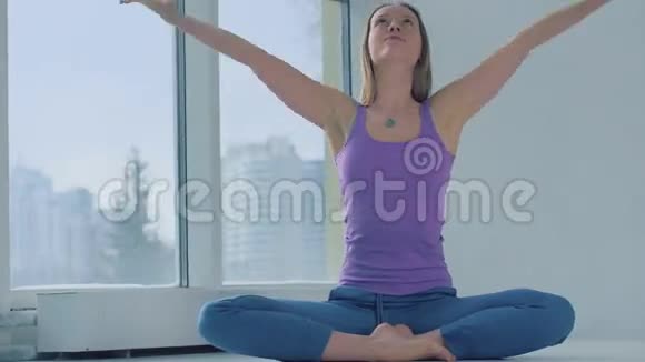 瑜伽女人在窗户背景下练习轻松姿势视频的预览图
