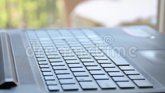 男性手在笔记本电脑上打字背光照明视频的预览图