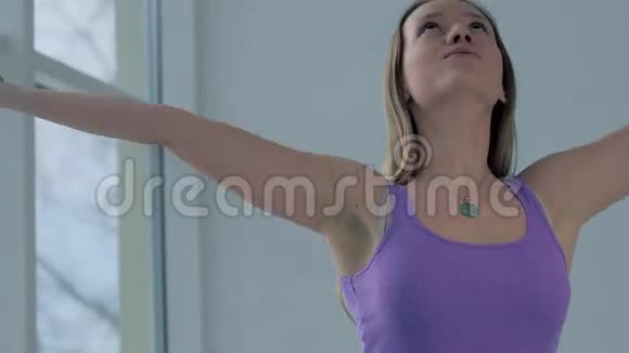 一位身材苗条的年轻女子在练瑜伽时将双手伸向纳玛斯特的肖像视频的预览图