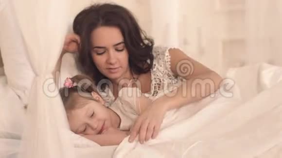有爱心的母亲让她可爱的小女儿入睡的画像视频的预览图