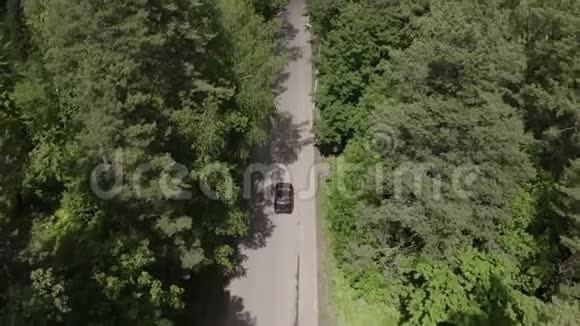 顶景黑车穿过夏林在乡间小路上行驶视频的预览图