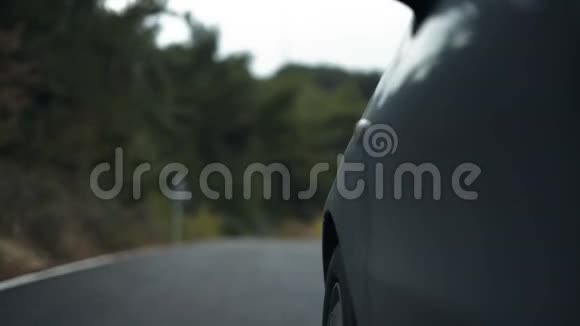 汽车左前轮在扭曲的道路上的特写镜头视频的预览图
