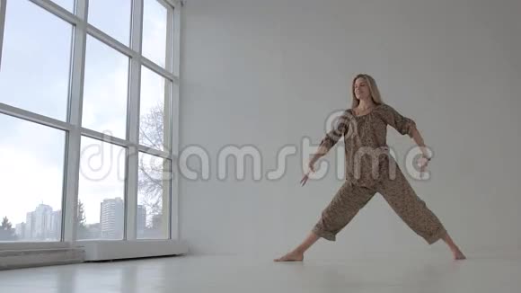 美丽的瑜伽女人练习瑜伽站在旋转的侧角姿势视频的预览图