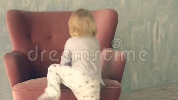 可爱的小女孩爬上扶手椅玩得开心视频的预览图