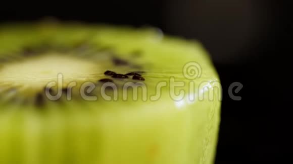 一只猕猴桃的宏射一只猕猴桃在黑色背景上特写黑色背景上的多汁绿色猕猴桃果果接近视频的预览图