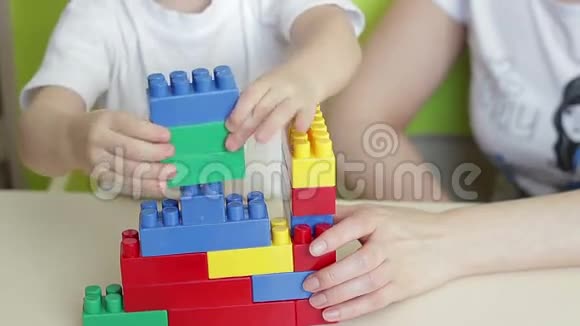 孩子和妈妈的手玩彩色积木视频的预览图