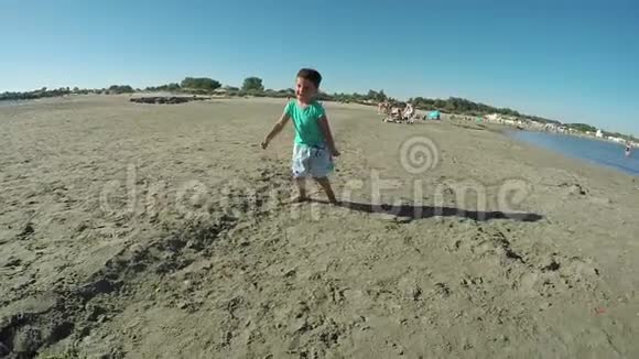 小男孩在海滩上踢足球视频的预览图
