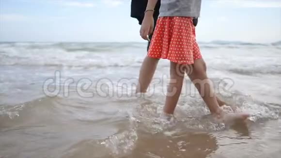 慢动作亚洲小女孩和妈妈在海滩上玩耍视频的预览图