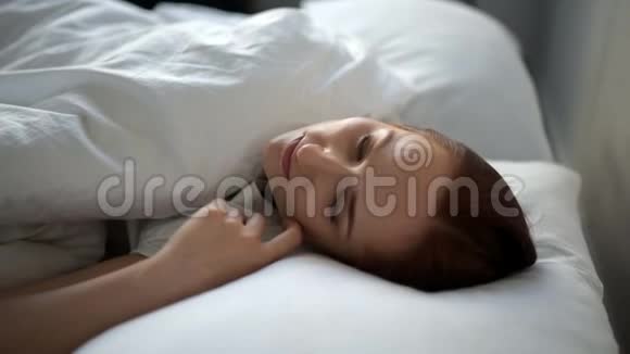 无精打采的女人躺在家里的床上视频的预览图