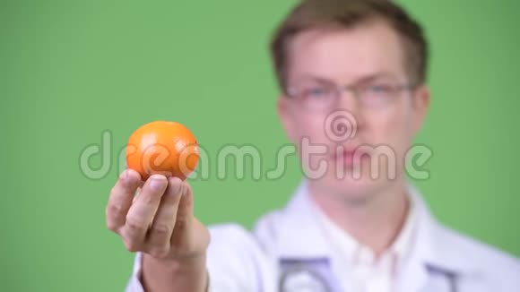 持有橙果的青年医生画像视频的预览图