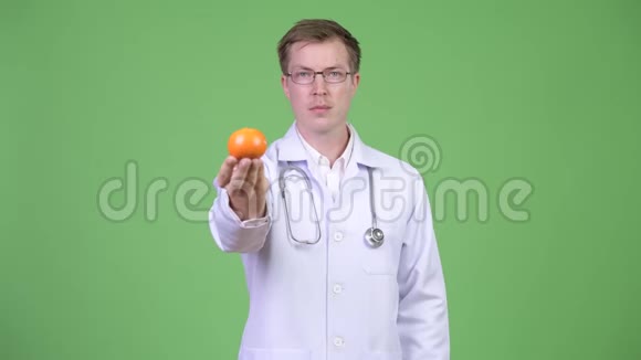 持有橙果的青年医生画像视频的预览图