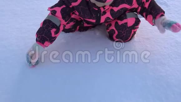 一个快乐的孩子在粉红色的整体玩雪视频的预览图