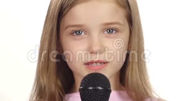 童女将歌曲唱入话筒白色背景关门视频的预览图