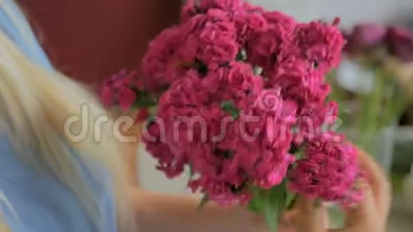 专业花艺师在工作坊为花束准备粉色土耳其康乃馨视频的预览图
