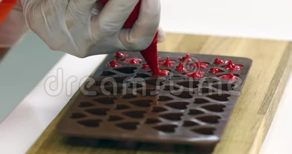 有人把巧克力塞进巧克力模子里视频的预览图