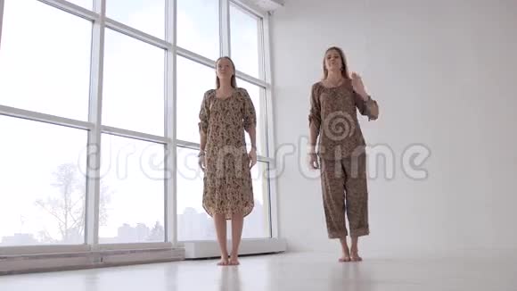 两个年轻的瑜伽女练鹰姿在寡妇面前视频的预览图