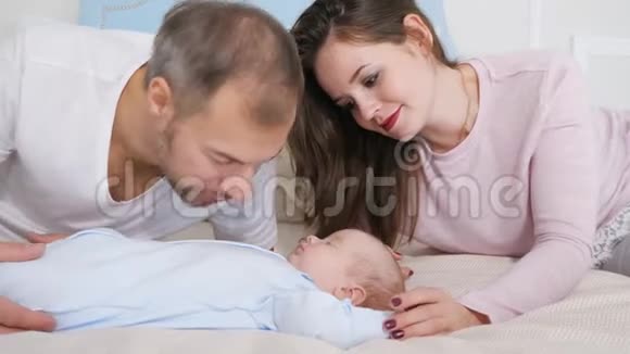快乐的父母在卧室里看着熟睡的宝宝视频的预览图