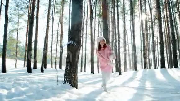 自由快乐美丽的女孩在树林里散步快乐阳光阳光透过树的背光许多雪视频的预览图
