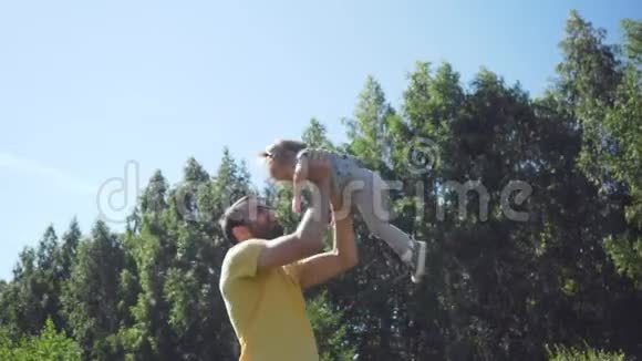 年轻的父亲把他的小女儿扔到户外视频的预览图