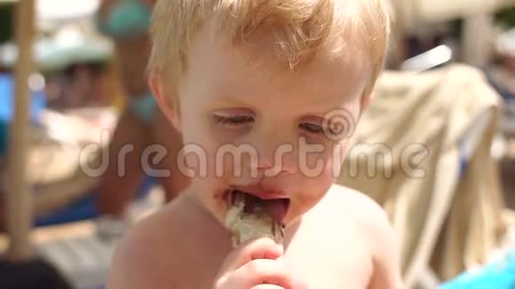 在海滩上吃巧克力冰淇淋的男孩视频的预览图