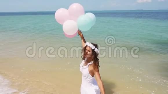 欢乐的女孩在海滩上奔跑手里拿着气球慢动作概念幸福自由视频的预览图