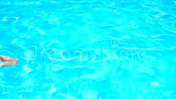 一个年轻漂亮的女孩头发湿漉漉的眼镜飘在蓝色的游泳池里视频的预览图