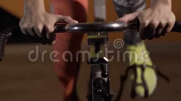 骑着一辆静止自行车的运动型年轻女子的特写镜头视频的预览图