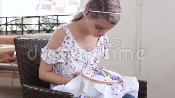 小女孩在咖啡馆缝针针线活刺绣爱好手工艺视频的预览图