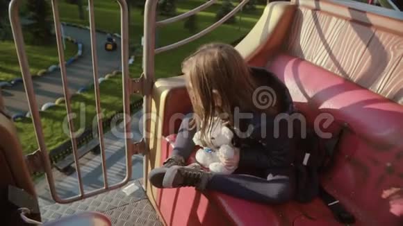 小可爱快乐的女孩带着玩具熊从高处看公园视频的预览图