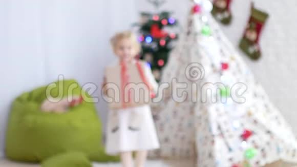 这孩子正拿着一件礼物给照相机圣诞节的心情奇迹和礼物的时间视频的预览图