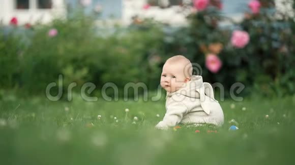 可爱的幼儿宝宝白天在公园草地上玩耍视频的预览图