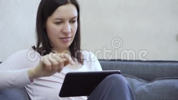 坐在沙发上用平板电脑的女人视频的预览图
