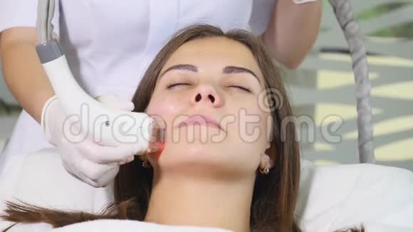 在美容院里偷射频电的女人有刺激面部治疗的女人护肤的脸皮肤治疗视频的预览图
